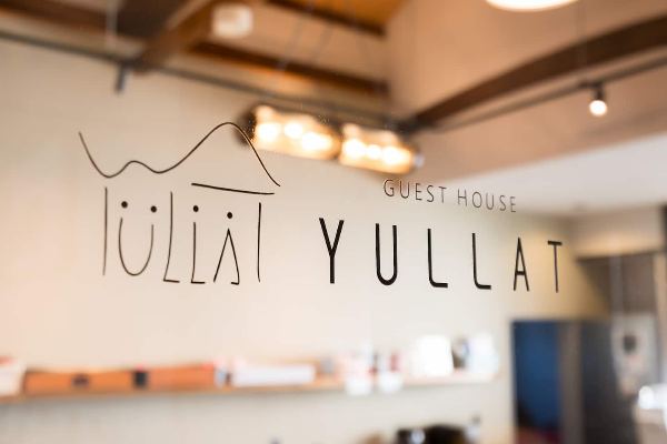 ガラスに描かれたGUEST HOUSE YULLATのロゴサイン